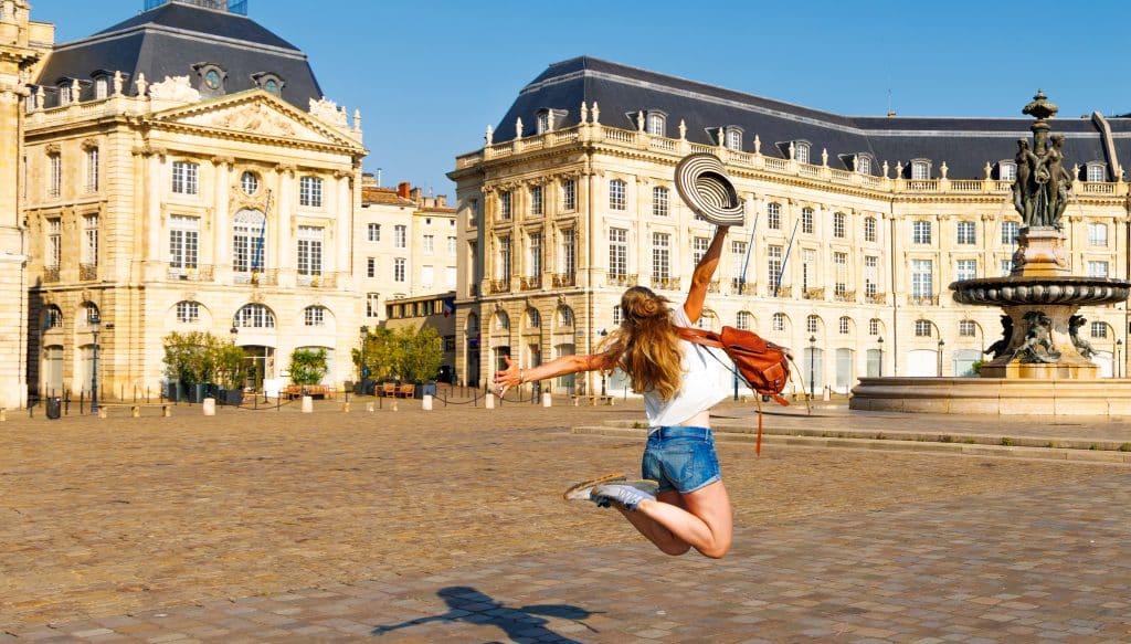 Jeune femme enjouée sur la Place de la Bourse de Bordeaux